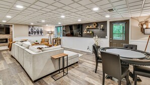 Een ruime woonkamer met een bank, salontafel en een eettafel met stoelen.