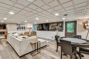 A spacious living area with a sofa, coffee table, and a dining table with chairs. - 'The Blue Goose Chalet': Your Cozy Up North Escape (Gaylord)