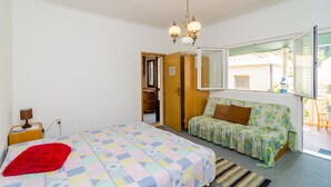 A bedroom with a bed, a sofa, a wardrobe, a mirror, and a window. - Apartments Rasica Molunat - One Bedroom Apartment (Konavle)