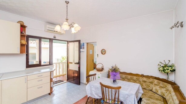 A compact living space with a kitchenette, dining area, and a sofa. - Apartments Rasica Molunat - One Bedroom Apartment (Konavle)