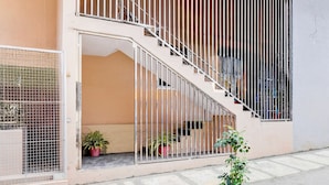 A modern building with a staircase leading to an upper floor, a gated entrance, and potted plants outside. - Collection O Brookefield Central (Bengaluru)