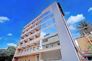 A multi-story building with a modern architectural design, featuring balconies and large windows. - Collection O Brookefield Central (Bengaluru)
