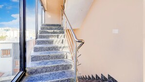 A staircase with metal railings and granite steps leading to an upper floor. - Collection O Brookefield Central (Bengaluru)