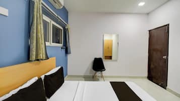 Quarto com cama, cadeira, guarda-roupa e espelho.