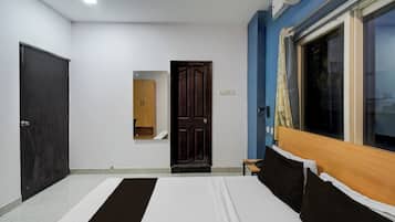 A bedroom with a bed, a wardrobe, a door, and a window.