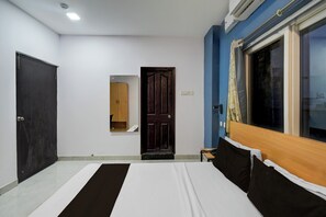 Un dormitorio con cama, armario, puerta y ventana.