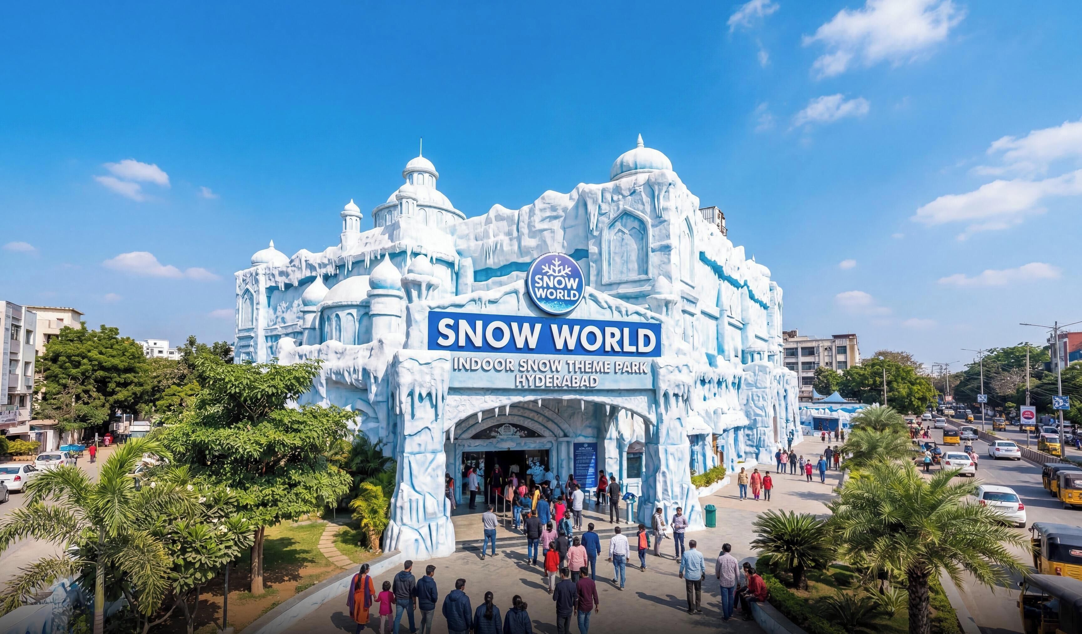 Entrada a un parque temático de nieve en interiores, con un letrero grande, una multitud de personas y un cielo azul despejado.