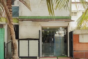 Una entrada de edificio con techo de tejas, puerta de cristal y portón de metal.