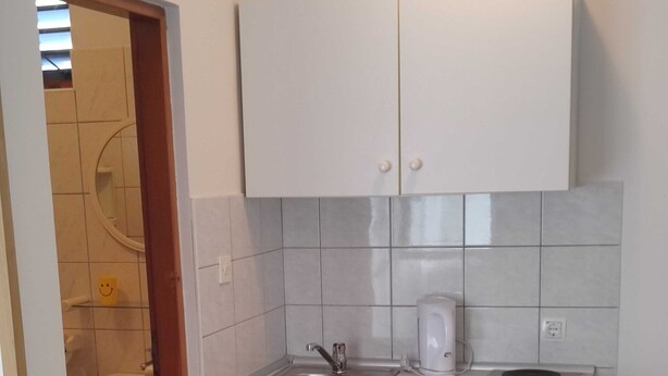 A compact kitchen with a sink, a coffee maker, and a small refrigerator. - Apartments Blaza - Studio Apartment (Vodice)