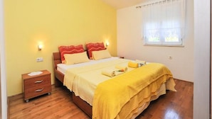 A bedroom with a bed, bedside tables, a window with curtains, and a wooden floor. - Apartment Spalato - Three Bedroom Apartment With Terrace (Bibinje)