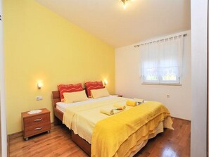 A bedroom with a bed, bedside tables, a window with curtains, and a wooden floor. - Apartment Spalato - Three Bedroom Apartment With Terrace (Bibinje)