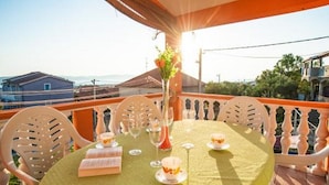 A table set for two with a green tablecloth, white chairs, and a vase with flowers. - Apartment Spalato - Three Bedroom Apartment With Terrace (Bibinje)
