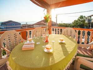 A table set for two with a green tablecloth, white chairs, and a vase with flowers. - Apartment Spalato - Three Bedroom Apartment With Terrace (Bibinje)