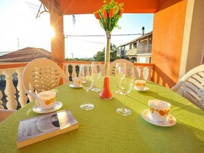 A table set for two with a green tablecloth, white chairs, and a vase with flowers. - Apartment Spalato - Three Bedroom Apartment With Terrace (Bibinje)