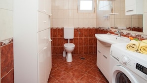 A compact bathroom with a toilet, sink, and washing machine. - Apartment Spalato - Three Bedroom Apartment With Terrace (Bibinje)