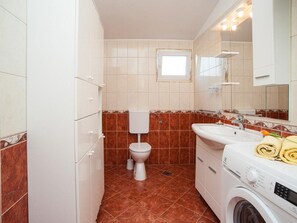A compact bathroom with a toilet, sink, and washing machine. - Apartment Spalato - Three Bedroom Apartment With Terrace (Bibinje)