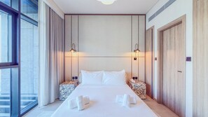 A hotel room with a large bed, two bedside tables, a wardrobe, and a large window. - Marina Living Residences - Dubai Marina (Dubai)