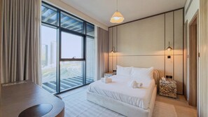 Ein Hotelzimmer mit großem Fenster, einem Bett, Nachttischlampen und einem kleinen Tisch.