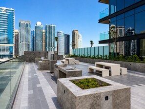 Eine Dachterrasse mit moderner Gartenmöbel, einem Wasserspiel und Blick auf eine Stadtansicht.