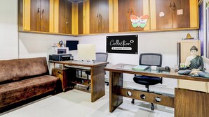 Una habitación con escritorio, sofá y una estatua. Un cartel en la pared dice 'Collection Company-Serviced'.