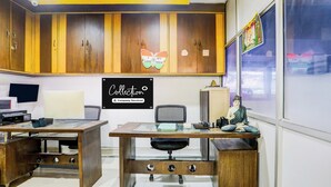 Una habitación con armarios de madera, un escritorio, una computadora y una estatua de Buda.