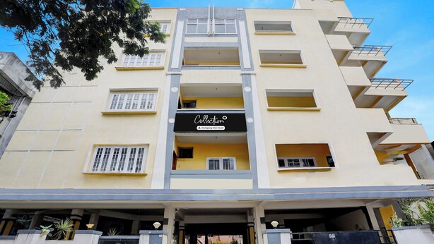 Un edificio de varios pisos con entrada central, balcones y un letrero que indica un servicio de empresa.