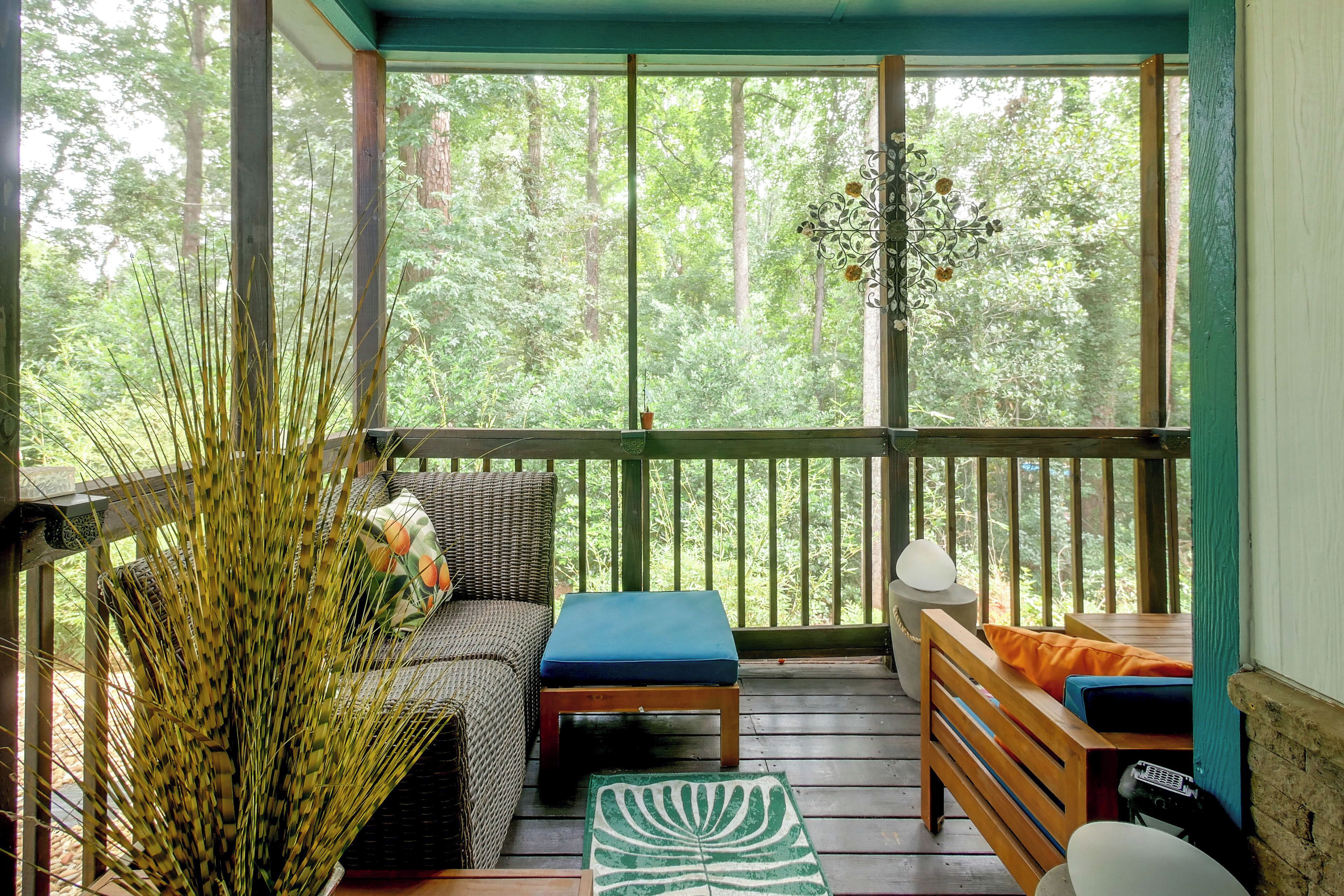 A covered outdoor seating area with a sofa, a small table, and a bench.