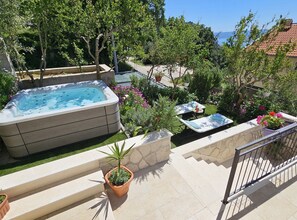 A hot tub surrounded by potted plants and outdoor furniture on a sunny terrace. - Holiday Home Sunrise - Three Bedroom Holiday Home (Omis)