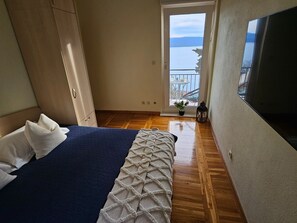 A bedroom with a bed, a window with a view, and a TV on the wall. - Holiday Home Sunrise - Three Bedroom Holiday Home (Omis)