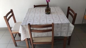 A dining table with a patterned tablecloth, surrounded by wooden chairs with cushioned seats. - Apartmani Villa Borzic - One Bedroom Apartment With Terarce and Sea View (Omis)