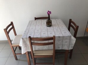 A dining table with a patterned tablecloth, surrounded by wooden chairs with cushioned seats. - Apartmani Villa Borzic - One Bedroom Apartment With Terarce and Sea View (Omis)