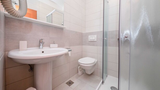A modern bathroom with a sink, toilet, and glass shower enclosure. - Guest House Villa Anggela - Double Room With Balcony and Sea View (Rab)