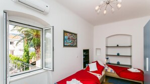 A room with two beds, a window, a painting, and a ceiling light fixture. - Villa Marini Dvori - Two-bedroom Apartment With Terrace (Dubrovnik)