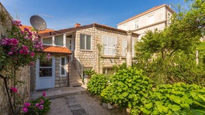 A stone house with a garden, a satellite dish, and a staircase leading to the entrance. - Villa Marini Dvori - Two-bedroom Apartment With Terrace (Dubrovnik)