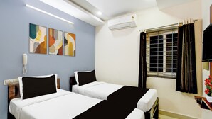 A hotel room with two beds, a wall-mounted phone, an air conditioner, a window with curtains, and artwork on the wall. - Super Collection O Khajaguda Hills (Hyderabad)