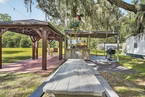An outdoor patio area with a wooden pergola, a picnic table, and a barbecue grill. - 6 Mi to Rainbow Springs! Home w/ Outdoor Space (Ocala)