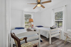 A room with two single beds, a ceiling fan, and a window with blinds. - 6 Mi to Rainbow Springs! Home w/ Outdoor Space (Ocala)