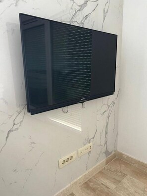 Ein flachbildfernseher an einer Wand mit Marmoroptik.