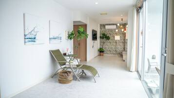 A modern interior with a dining area, a living space, and a view through a glass door.