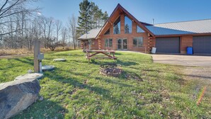 A log cabin with a large garage and a picnic table in the yard. - Secluded Log Cabin < 1 Mi to Munger State Trail! (Finlayson)