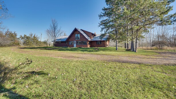 A log cabin with a front porch, surrounded by a grassy field and trees. - Secluded Log Cabin < 1 Mi to Munger State Trail! (Finlayson)