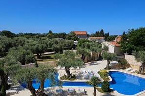 A resort with a swimming pool, lounge chairs, and Mediterranean-style buildings. - Villa Ponto - Studio Apartment With Terrace (A4) (Kaluderac)