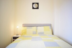 A bed with a quilt, a bedside lamp, and a wall-mounted artwork. - Bright home close to Dublin city centre- sleeps 4! (Dublin)