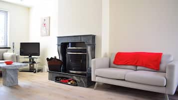 A living room with a fireplace, a sofa, a television, and a coffee table.