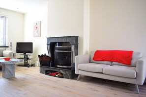 A living room with a fireplace, a sofa, a television, and a coffee table. - Bright home close to Dublin city centre- sleeps 4! (Dublin)