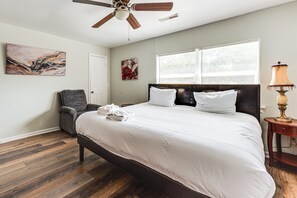 A bedroom with a large bed, a ceiling fan, a chair, a window with blinds, and artwork on the walls. - 9 Mi to Dtwn Charleston! Park Circle Extended Stay (North Charleston)