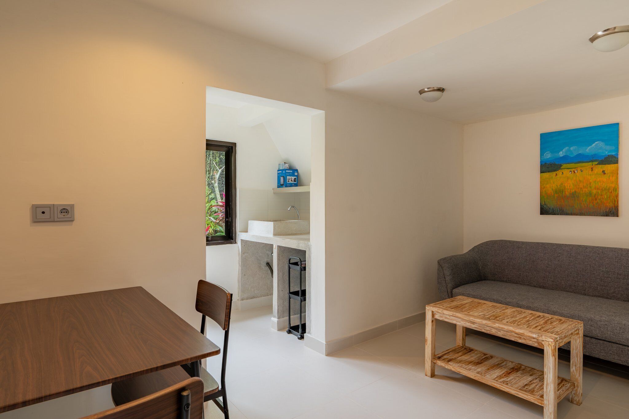 Un espacio habitable moderno con comedor, sofá y un cuadro en la pared.