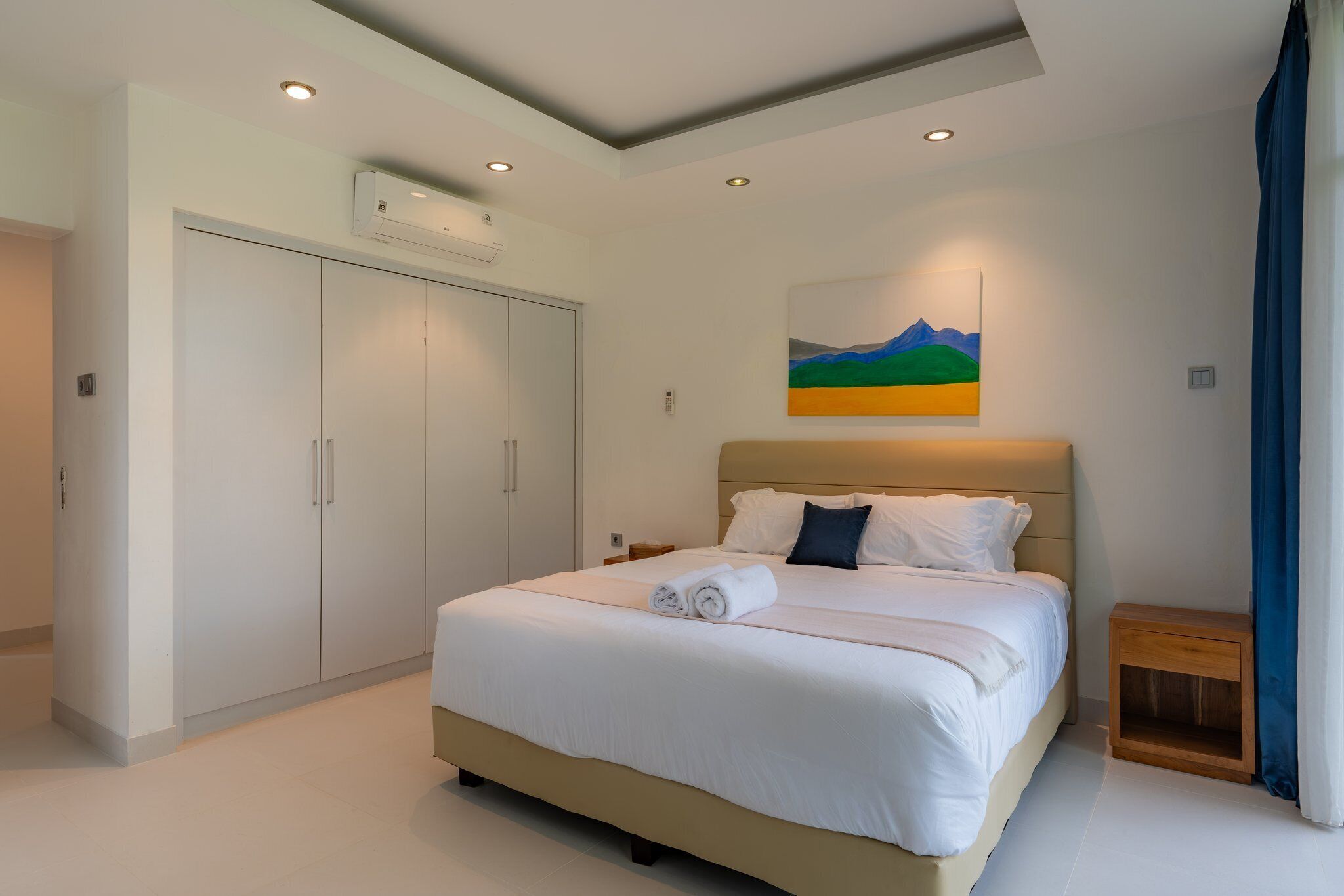 A bedroom with a bed, a wardrobe, a painting, and a nightstand.