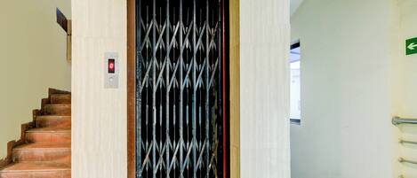 A staircase leading to a door with a security keypad and a metal grille.