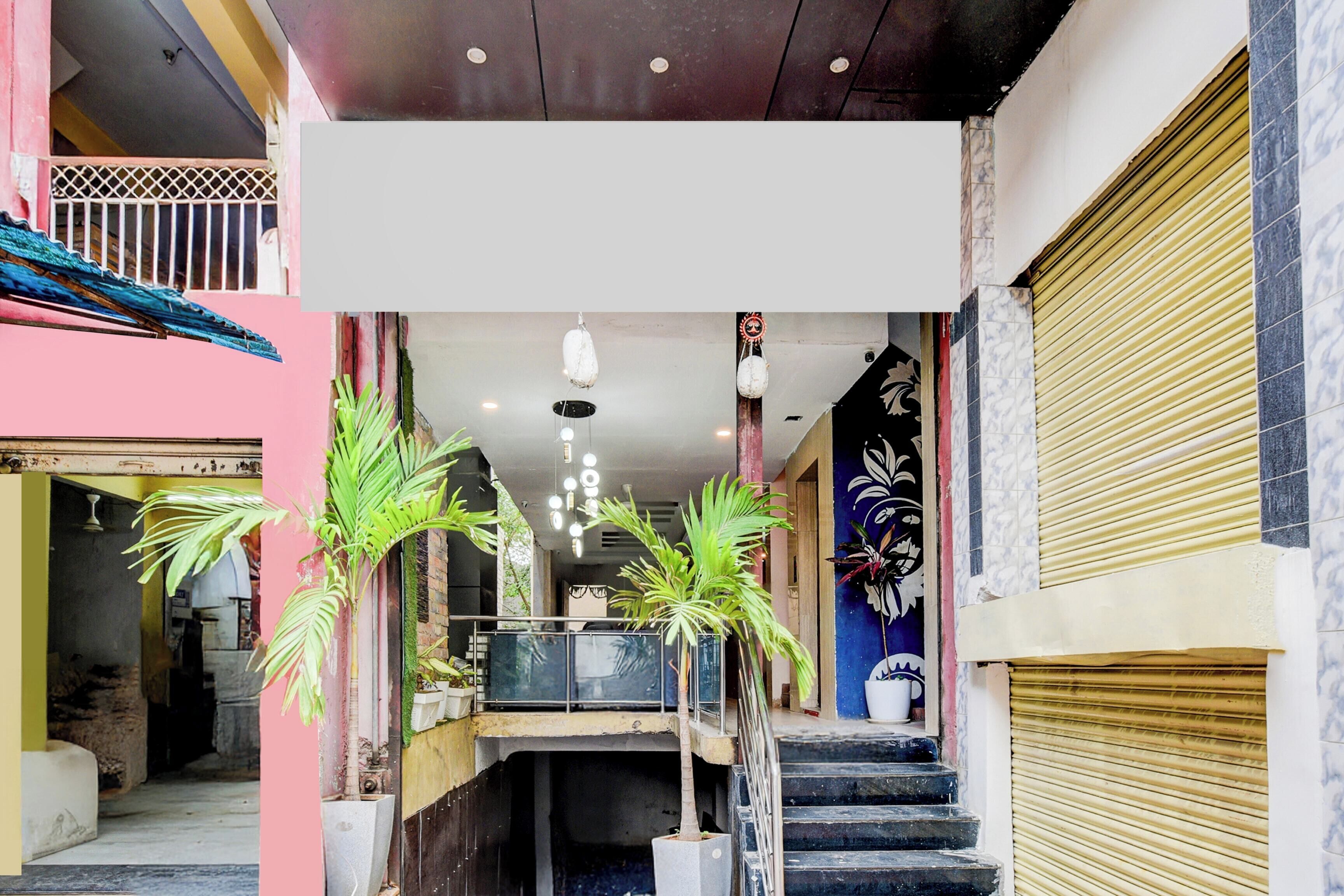 A multi-level building with a staircase, potted plants, and a decorative wall.